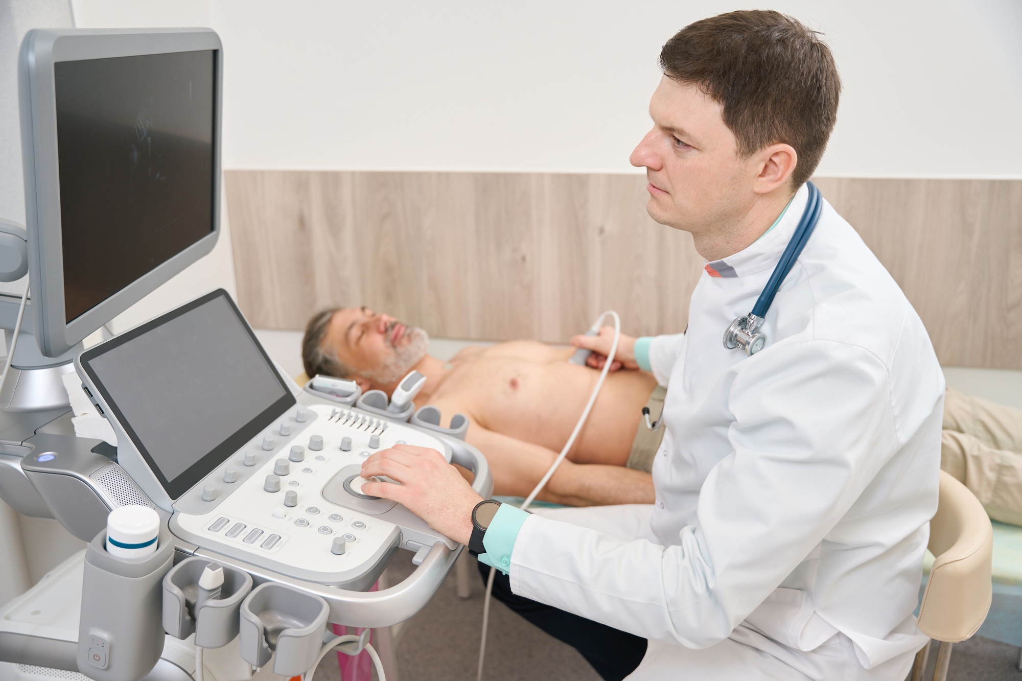 Physician scanning heart of male in the hospital