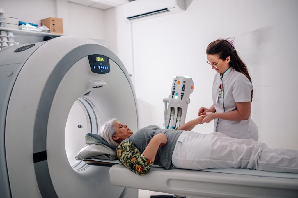 Healthcare professional assisting patient for a CT diagnostic scan.